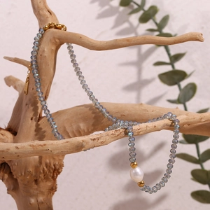 Detail of dark blue crystal beads and a white baroque pearl on a vintage beaded necklace
