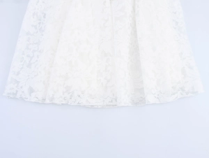 Detailed close-up of white floral lace embroidery on the sheer tulle hem of the dress