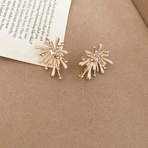 Detail of fireworks-shaped earrings with gold and off-white enamel and crystal inlay