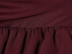 Detail of burgundy woven fabric showing elegant ruched texture and pleated design