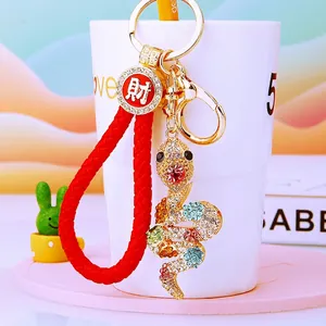 Detail of snake keychain with sparkling rhinestones, woven rope, and golden charm