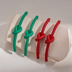 Orecchini a nodo minimalisti opachi in verde e rosso su espositore elegante