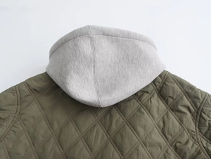 Detail of army green quilted puffer jacket showing diamond stitching and grey hood