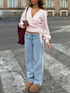 Pink V-neck wrap knit top paired with light blue straight-leg jeans in street style
