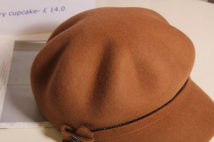 Detail of wool octagonal cap with beaded trim and a matching bow decoration