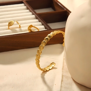 18K gold plated stainless steel open bangle with shell wave texture on ceramic holder