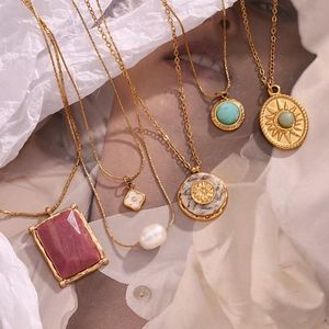 Flat lay of 18K gold plated necklaces featuring natural stones and vintage pendants