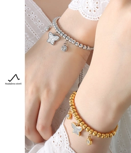 Close-up of model wearing stainless steel beaded bracelet with crystal butterfly charm