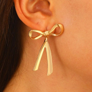 Fairy zircon bow knot earrings in gold finish worn by model showing elegant design