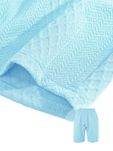 Detail of light blue textured knit shorts featuring waffle weave fabric and drawstring waist