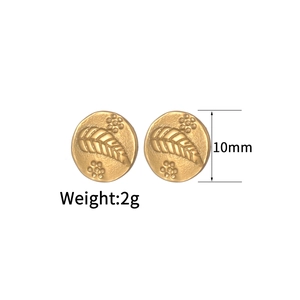Macro detail of 10mm round golden bee earrings with embossed leaf and dot textures