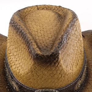 Detailed close-up of textured woven paper straw crown with western rivet band