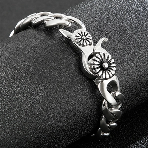 Macro view of retro stainless steel Cuban chain bracelet with floral relief clasp