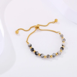 Adjustable gold bead bracelet with marble-textured stones on a white gift background
