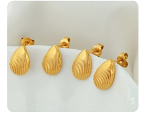 Macro detail of gold-tone shell-shaped stud earrings with refined vertical textures