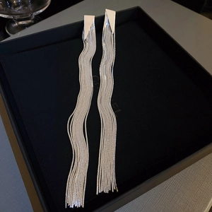 Detailed view of silver-tone long tassel earrings with geometric triangles and wavy chains