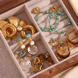 Detail of diverse boho earrings with natural stones in a wooden jewelry organizer tray
