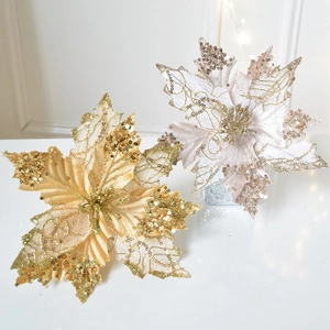 Champagne and gold glitter poinsettia flowers for Christmas tree decoration on white surface