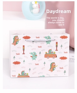 Detailansicht der Geschenktüte aus Papier mit Dinosaurier-Motiv und silbernen Tragekordeln