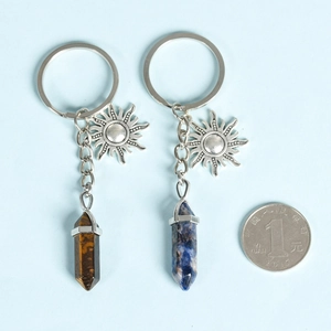 Tiger eye and lapis lazuli crystal pillars with sun pendants on metal keychains