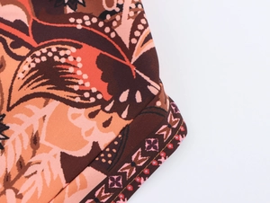 Detail of bohemian floral print fabric with brown and orange patterns and edge stitching