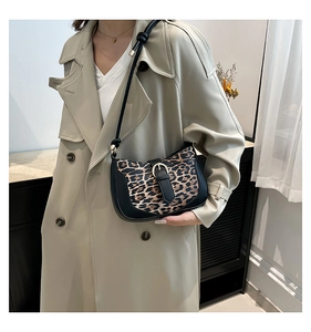 Fashionable leopard print shoulder bag with black leather trim and golden metal buckle details