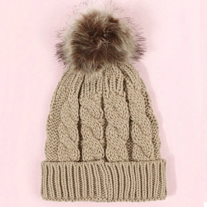 Chic cable knit winter beanie for kids in beige featuring a fluffy faux fur pompom