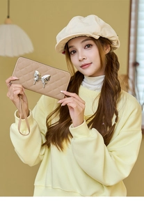 Quilted long wallet with silver butterfly charm and wrist strap in beige tone