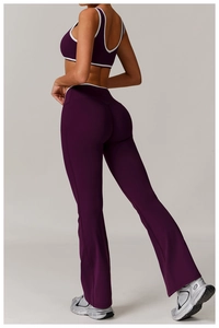 Detail view of high-waisted flare leggings and cross-back sports bra in dark purple