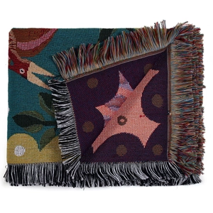 Detail of woven Bohemian picnic blanket with colorful tassels and intricate jacquard texture