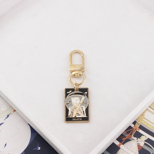 Tarot Death card keychain in gold alloy with black enamel and white skull charm
