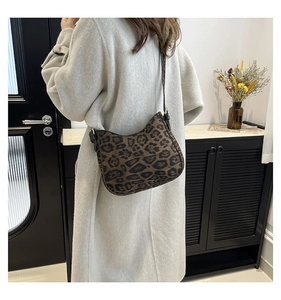 Detailed back view of a leopard print crescent hobo bag with a wide black shoulder strap