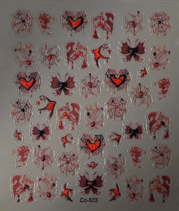 Macro shot of dark gothic nail art stickers with red glitter spider and bat motifs