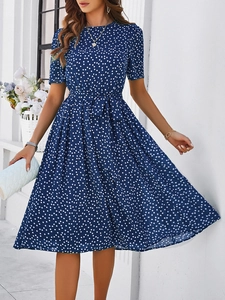 Détail de la robe midi bleu marine à pois avec ceinture nouée et coupe évasée