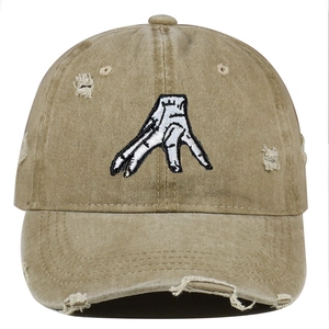 Close-up of distressed khaki baseball cap with vintage frayed edges and hand embroidery