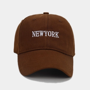 Close-up of white NEWYORK embroidery on brown cotton baseball cap with twill texture