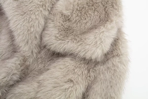 Close-up of soft faux fur texture in taupe showing dense plush fibers on luxury coat