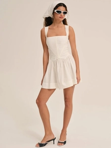 Detalle de vestido blanco sin mangas con escote cuadrado y cintura en V con falda plisada