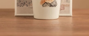 Detailed view of Ru Kiln ceramic teacup with a cute cartoon cat and traditional seal design