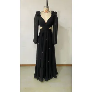 Detail of elegant black V-neck maxi dress featuring floral shoulder and silver bow embroidery