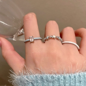Detail shot of three stylish rings featuring blue zircon, silver star, and white enamel