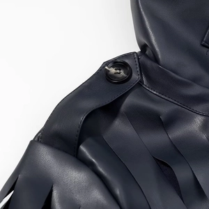 Detail of dark faux leather jacket featuring epaulette design and textured buttons