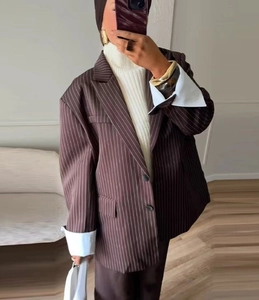 Close-up of brown striped oversized blazer with white lining on the folded cuffs
