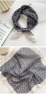 Detail of square silk scarf featuring black white geometric patterns and beige border