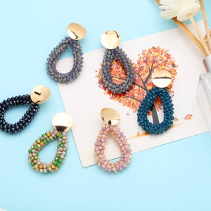Detailed view of handmade colorful teardrop beaded earrings with gold round studs