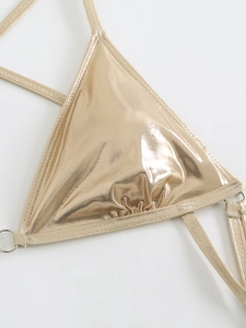Detail view of metallic gold bikini top with shiny coating and silver metal ring connector