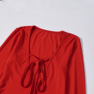 Detailed view of the red lace-up U-neckline on high-elasticity knitted dress