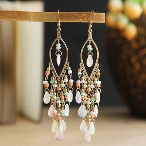 Detail of vintage bohemian tassel earrings with gold plating and colorful beaded accents