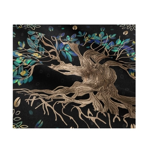 Close-up of tree of life pattern on black fabric with blue leaves and gold roots