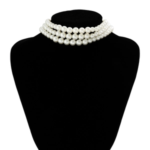 Detailed view of bohemian triple-layer cream white pearl necklace on black bust stand